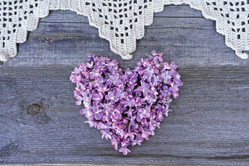 Lilac hart with lace on wooden background 