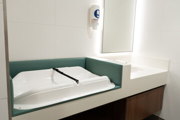 A table for changing a baby in a women's restroom.
