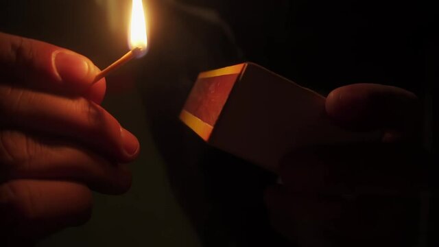 close-up of hand lighting a match in slow motion