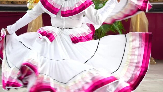 a cute mexican folklore ballerina dancer performing in her typical costume