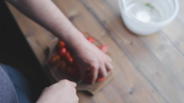 a man washes, cleans and cuts vegetables. Tomatoes, garlic, herbs