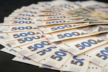 A lot of Ukrainian hryvnias, face value 500 hryvnias on a black background, nicely laid out money on black.