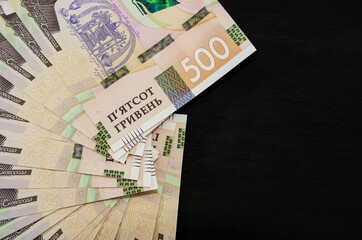 A lot of Ukrainian hryvnias, face value 500 hryvnias on a black background, nicely laid out money on black.