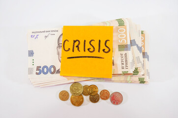 The word "crisis" on the sticker and 500 hryvnia, white background. Business concept Economic crisis concept.
