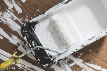 DIY and home improvement, paint tray with white glossy paint and paint roller