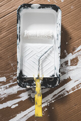 DIY and home improvement, paint tray with white glossy paint and paint roller