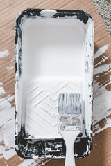 DIY and home improvement, paint tray with white glossy paint and paint brush