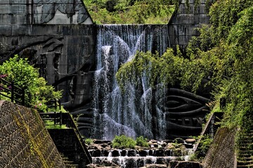 レリーフ模様のある堰堤を流れ落ちる水
