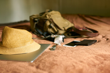 Concept travel prop with a hat and bag and laptop            