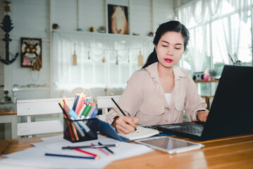 A beautiful woman working with a laptop computer in a coffee shop Beautiful business woman using a laptop sitting at a wooden table. Free translator working with a laptop. Concept: work at home