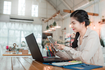 A beautiful woman working with a laptop computer in a coffee shop Beautiful business woman using a laptop sitting at a wooden table. Free translator working with a laptop. Concept: work at home