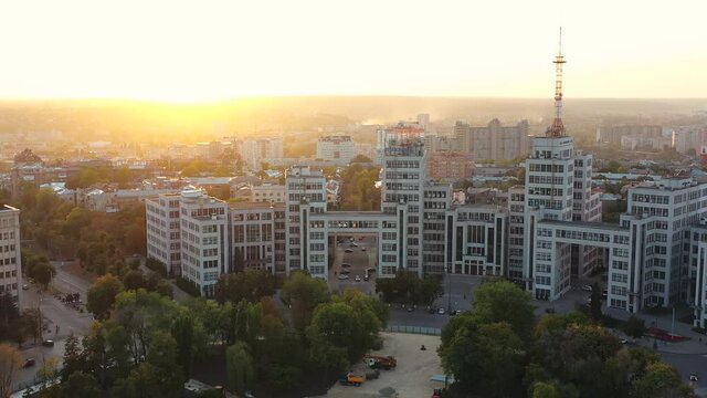 Distant aerial shot from the copter of the famous Soviet building of Derzhprom in the center of Kharkov on Freedom Square against the backdrop of residential buildings and beautiful sunset in spring.