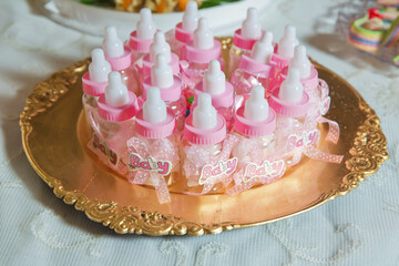 Baby bottle candy on the silver salver . Abstract of close view of infant milk bottle candy .