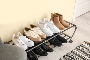 Stand with stylish shoes in interior of modern hall
