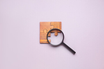 Pieces of jigsaw puzzle and magnifier on light background. Unity concept