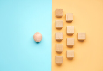 Wooden sphere and cubes on color background. Concept of uniqueness
