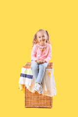 Little girl in dirty clothes eating chocolate on color background