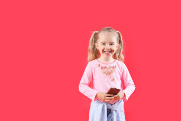 Little girl with chocolate stains on her clothes against color background