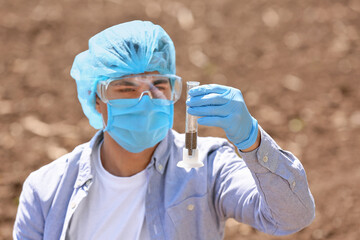 Scientist studying samples of soil in field