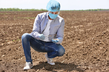 Scientist studying samples of soil in field