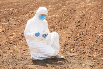 Scientist studying samples of soil in field