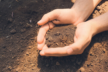 Agronomist with handful of soil in field, closeup