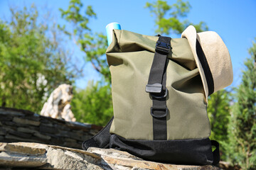 Traveler's backpack and hat in green park