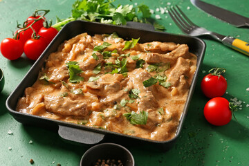 Tasty beef stroganoff on color background