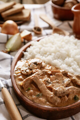 Plate with tasty beef stroganoff and rice on table, closeup