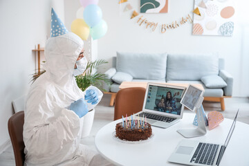 Asian man video chatting with friends on his Birthday at home. Concept of epidemic