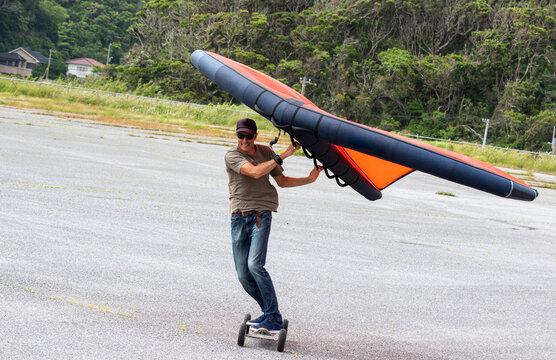 Wing Surfer, a man on a skateboard flying a wing, foil, sky wing, wing surf, it is a new extreme sport becoming popular all over the world, A new mode of transport that is fun. Katsuura, Chiba, Japan
