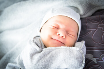 Beautiful newborn sweetly sleeps in the crib and has beautiful dreams