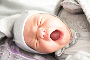 Beautiful newborn sweetly sleeps in the crib and has beautiful dreams