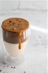 Dalgona coffee in crustal glass on the table at the morning with sunlight.