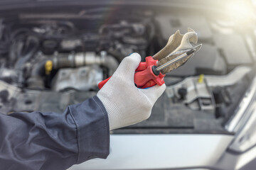 mechanic's hand with screwdriver repair or check car  in garage