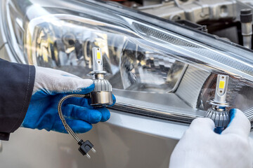 the mechanic replaces the halogen bulbs in the headlights in the car