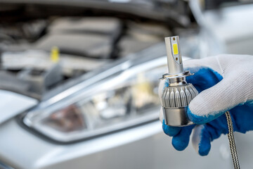 the mechanic replaces the halogen bulbs in the headlights in the car
