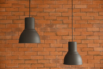 Hanging lamps against brick wall