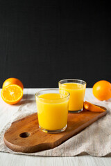 Healthy Orange Juice on a rustic board on a white wooden background, side view. Copy space.