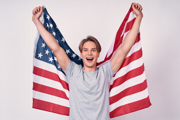 Happy young guy with american flag on a white background.