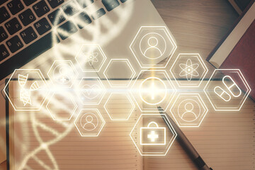DNA hologram drawings over computer on the desktop background. Top view. Multi exposure. Concept...