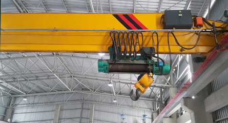 Close up of an overhead crane on a yellow beam wait repair