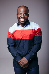 Portrait of an attractive muscular Frenchman smiling at the camera on a light background