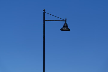 A black, decorative street lamp that has white bird poo on the lamp shade