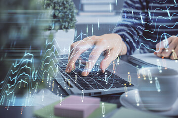 Double exposure of woman hands typing on computer and forex chart hologram drawing. Stock market invest concept.