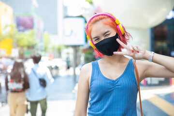 Girl teen cute punk hipster style red hair color wear face mask or face shield at outdoor public...