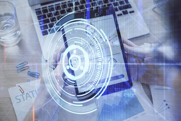 Double exposure of man's hand holding and using a digital device and data theme hologram drawing. Technology concept.