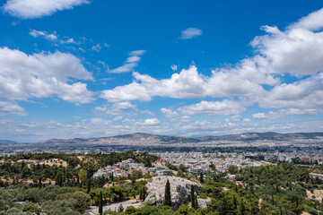 Fototapeta na wymiar Athens city against blue cloudy sky in a spring day. Aerial view from Acropolis hill. Attica, Greece,