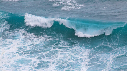 Fototapeta na wymiar Blue and white breaking ocean wave seen from above