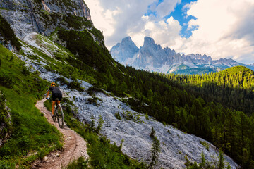Fototapeta na wymiar Cycling outdoor adventure in Dolomites. Cycling woman in Dolomites landscape. Woman cycling MTB enduro trail track. Outdoor sport activity.